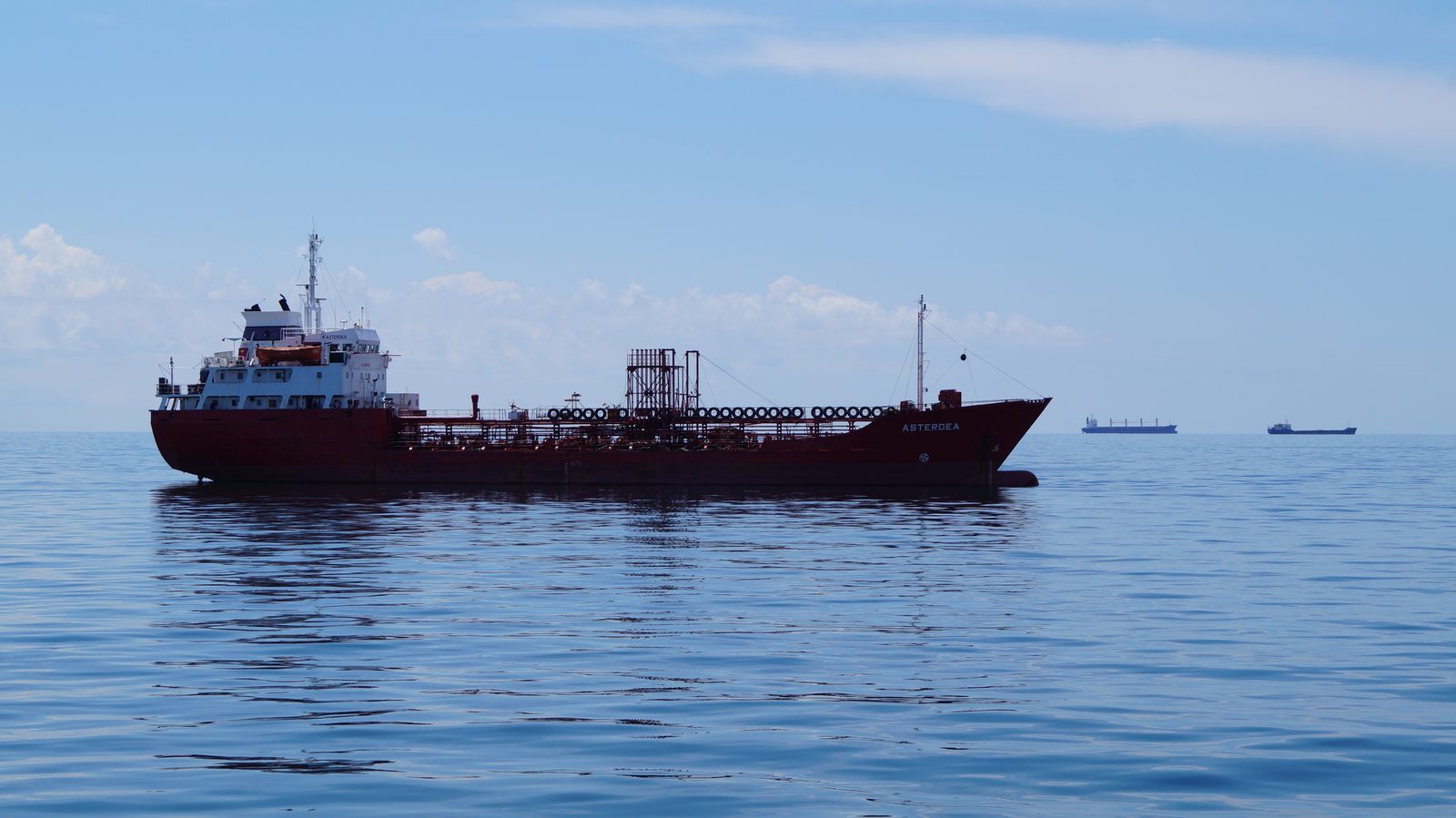Product tanker ASTERDEA lying at anchor in open water, further vessels on the horizon.